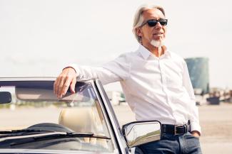 man posing by car